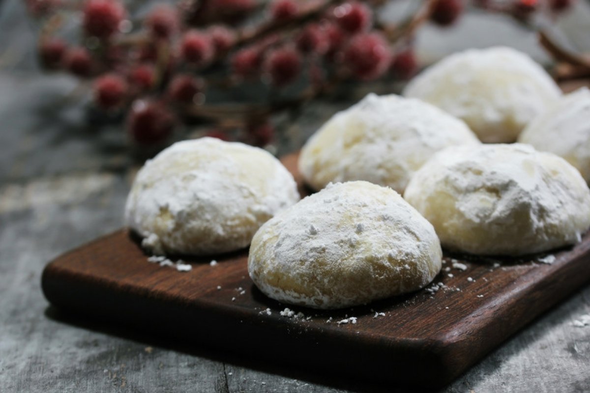 Snowball cookies served on a dark wooden board