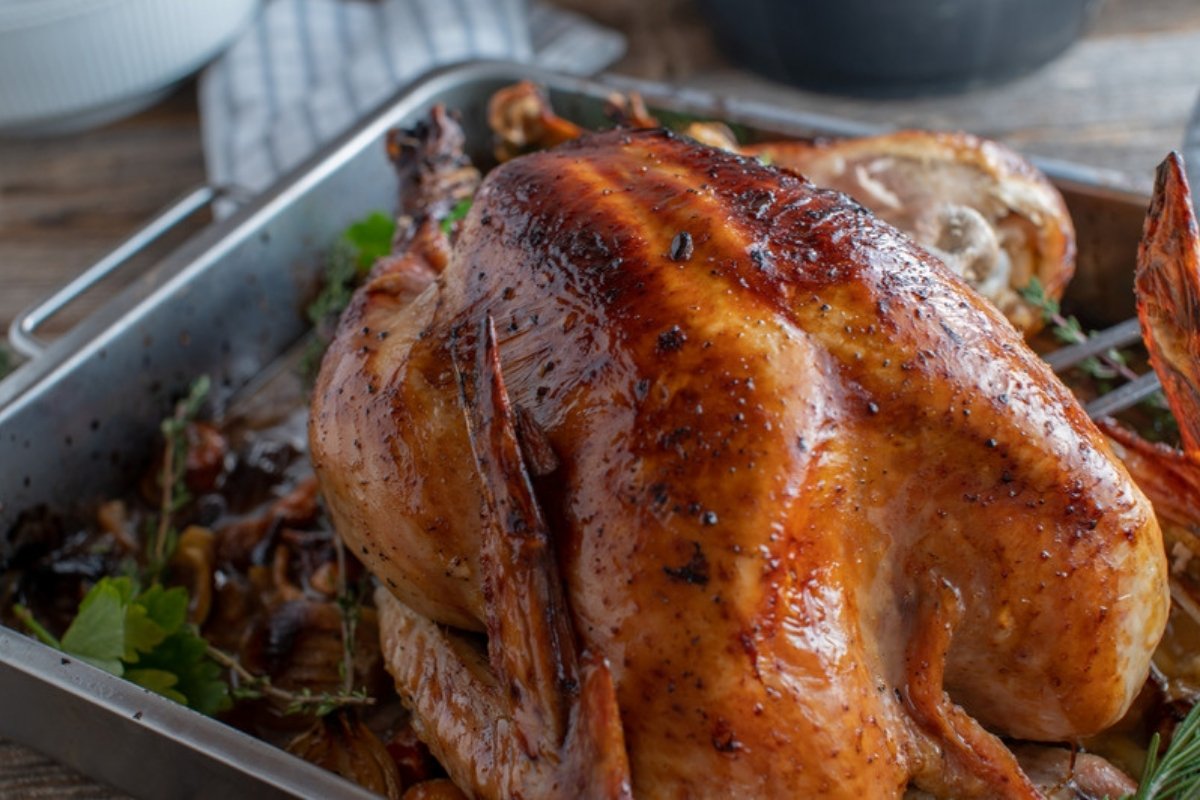 Roasted turkey in a roasting pan with pan drippings